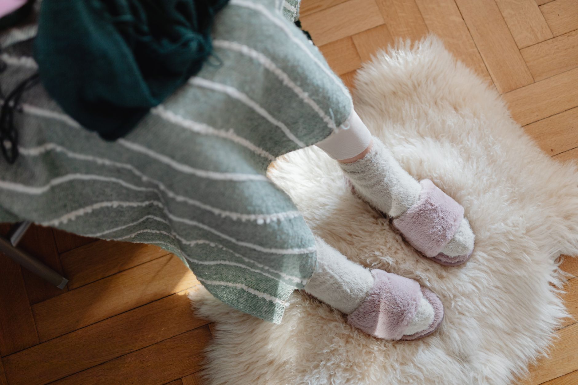 chaussons en peau de mouton posés dans un espace sec et ventilé, près d’une fenêtre mais éloignés d’un radiateur, illustrant les bons gestes d’entretien