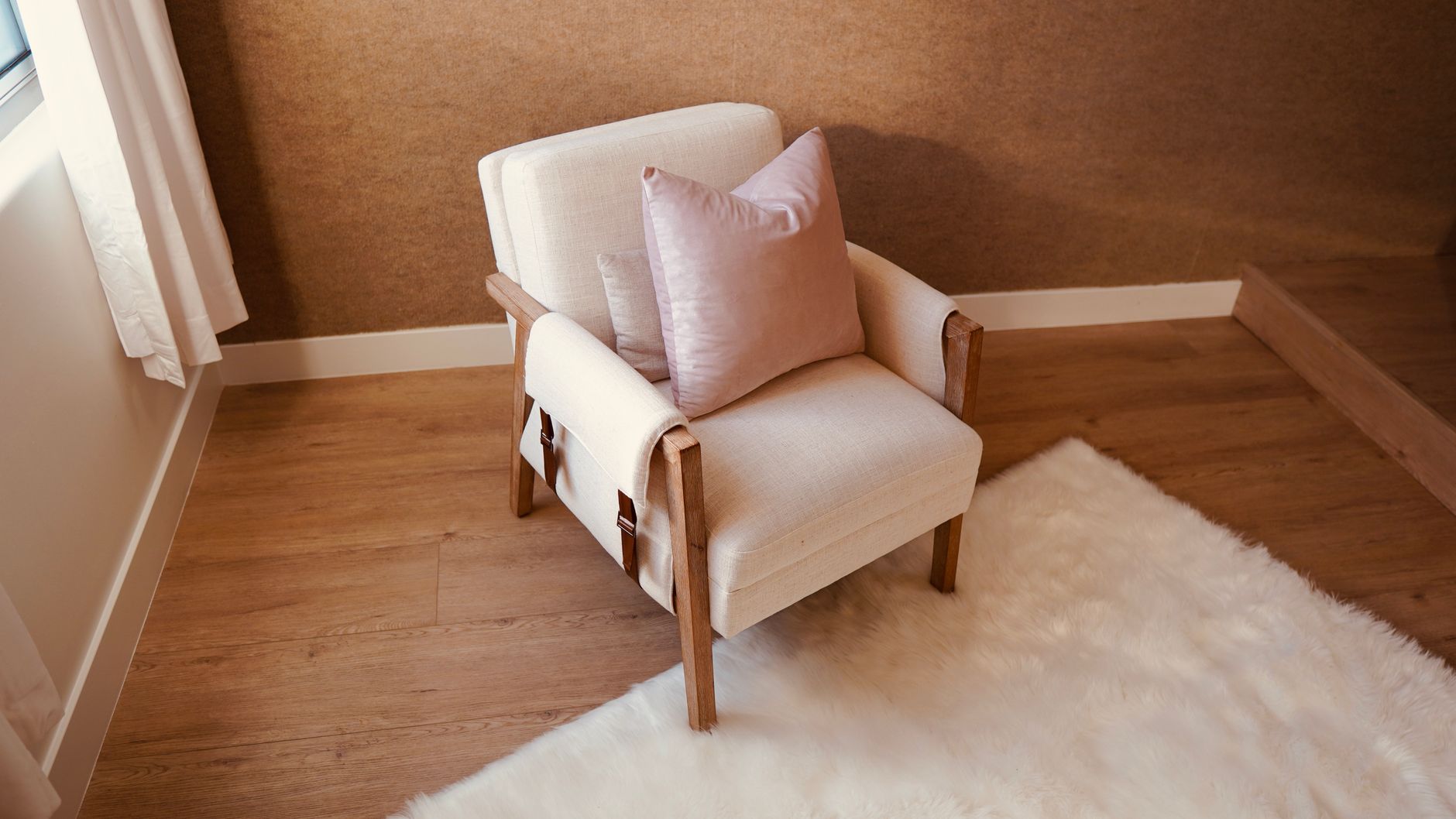 Intérieur de maison chaleureux montrant une personne portant des chaussons en peau de mouton près d’un fauteuil, avec une lumière douce et une ambiance cocooning.